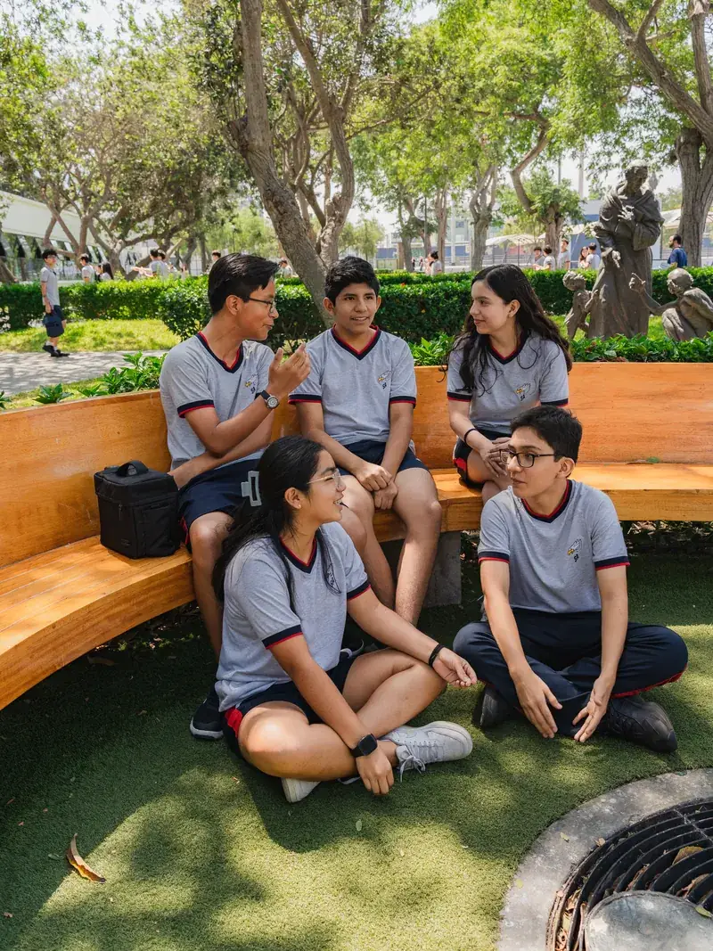 Estudiantes conversando en el jardín del colegio