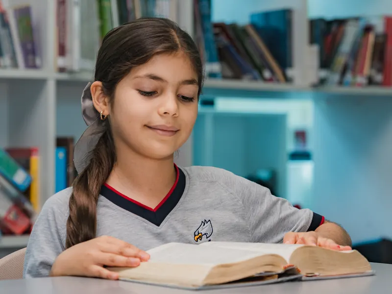 Estudiante de Primaria leyendo en la biblioteca
